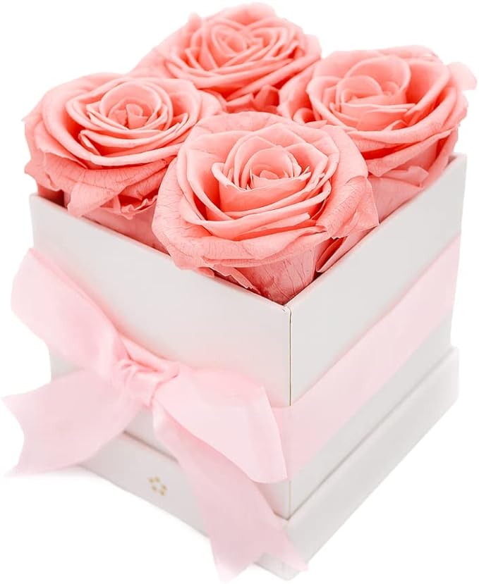 four pink roses in a white box.