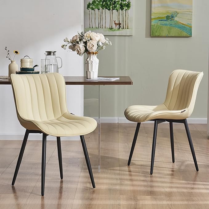 Two beige chairs, a table, and a vase in a room.