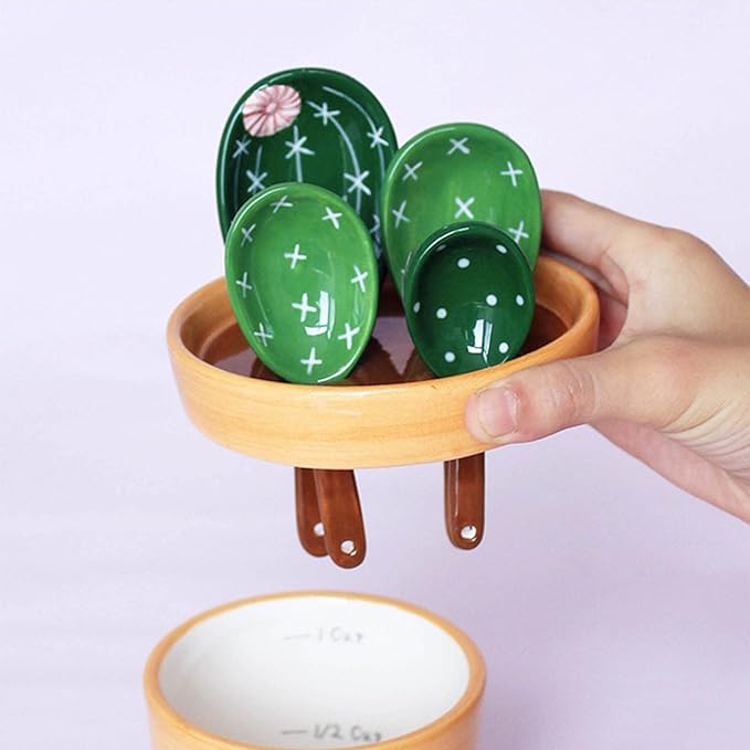 A person holding a set of cactus designed measuring spoons in purple background