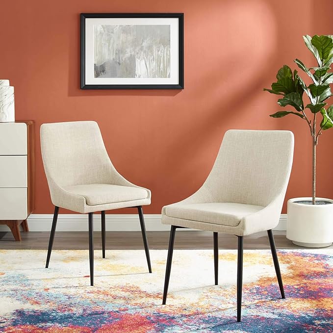 Two upholstered chairs placed in front of a vibrant rug, adding a pop of color to the room's decor.