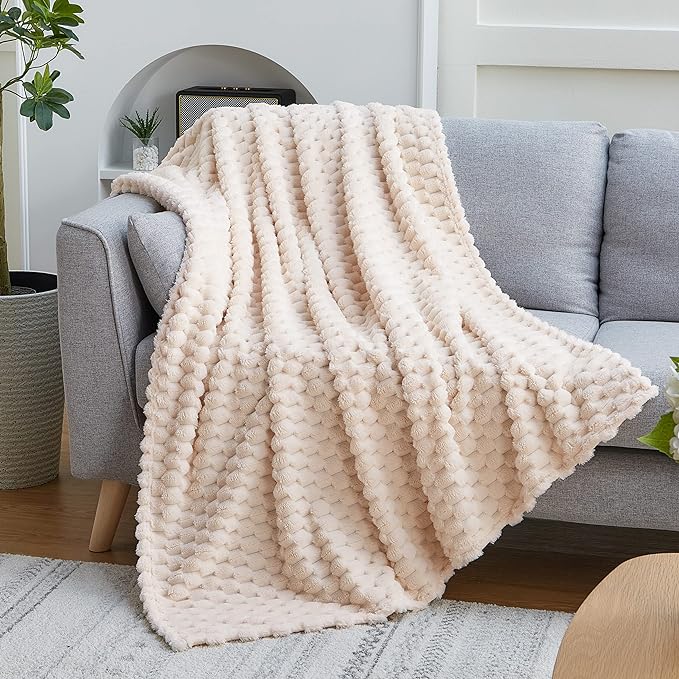 A white throw blanket on a chair in a living room.