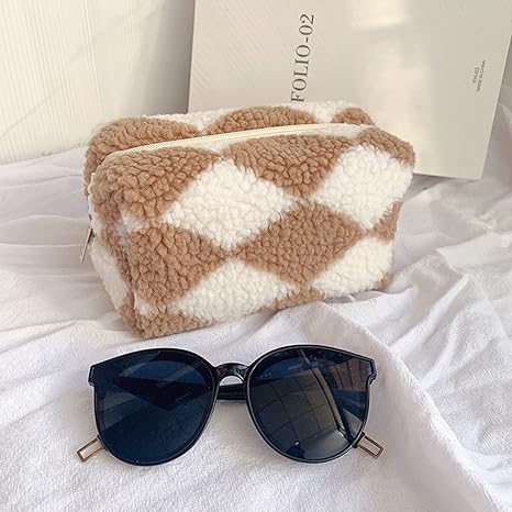 sunglasses and make up purse - laid out on a bed