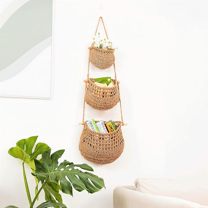 Three-tiered basket hanging on wall, perfect for organizing fruits or storing small items.