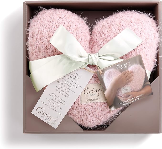 A pink heart shaped pillow in a gift box.