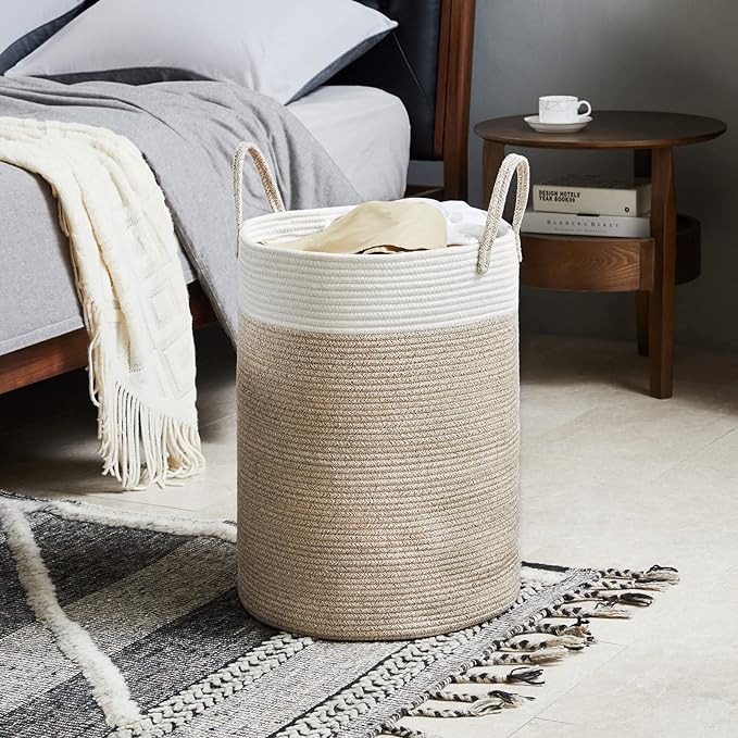 A spacious cotton-made laundry basket in white and beige, placed on a rug.