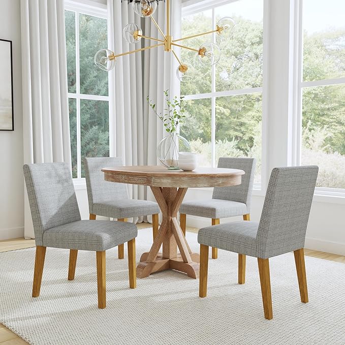 A dining room with a round table surrounded by chairs, elegantly set for a meal.