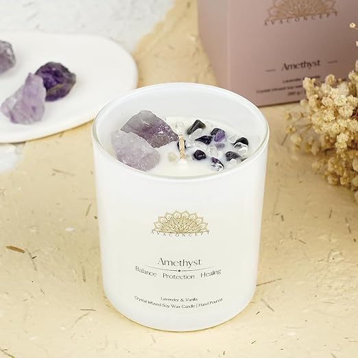 A candle surrounded by crystals and a box filled with crystals, creating a serene and mystical ambiance.