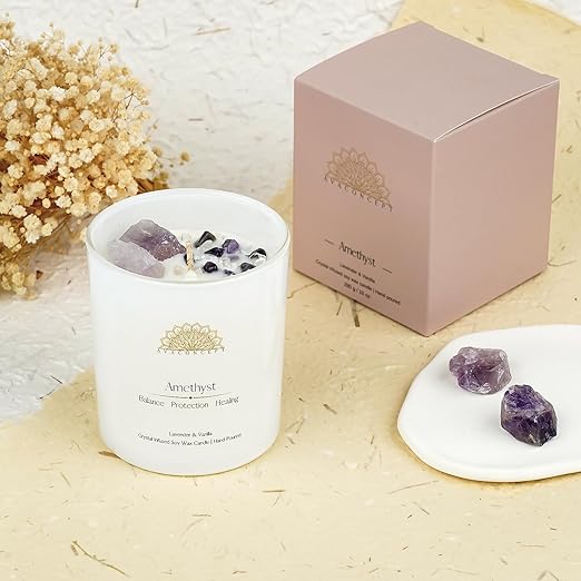 A candle with crystals and a packaging box, creating a serene ambiance.