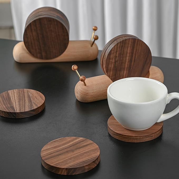 A coffee cup and two snail shaped wooden coasters placed on a table, ready for a hot beverage.