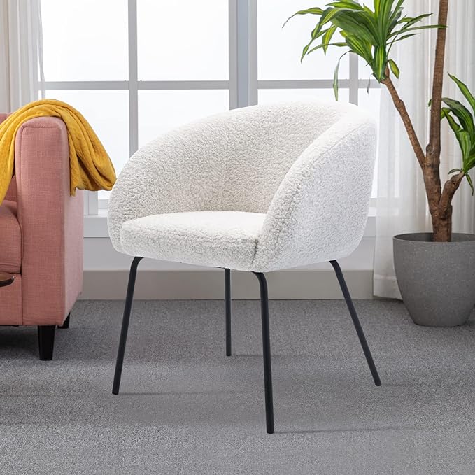 A white barrel chair in a room with a plant, creating a serene and minimalist ambiance.