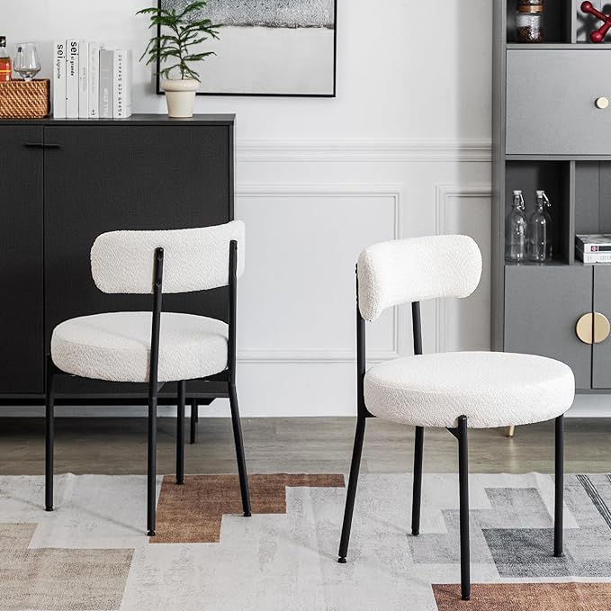 Two white chairs in a living room on a rug