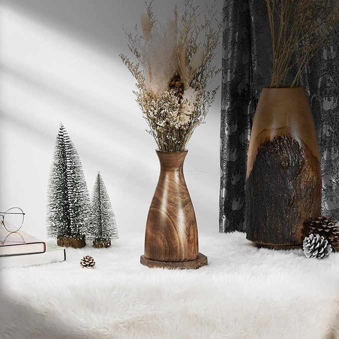 Two boho vases with dried flowers and a book resting on a white rug, creating a serene and elegant display.